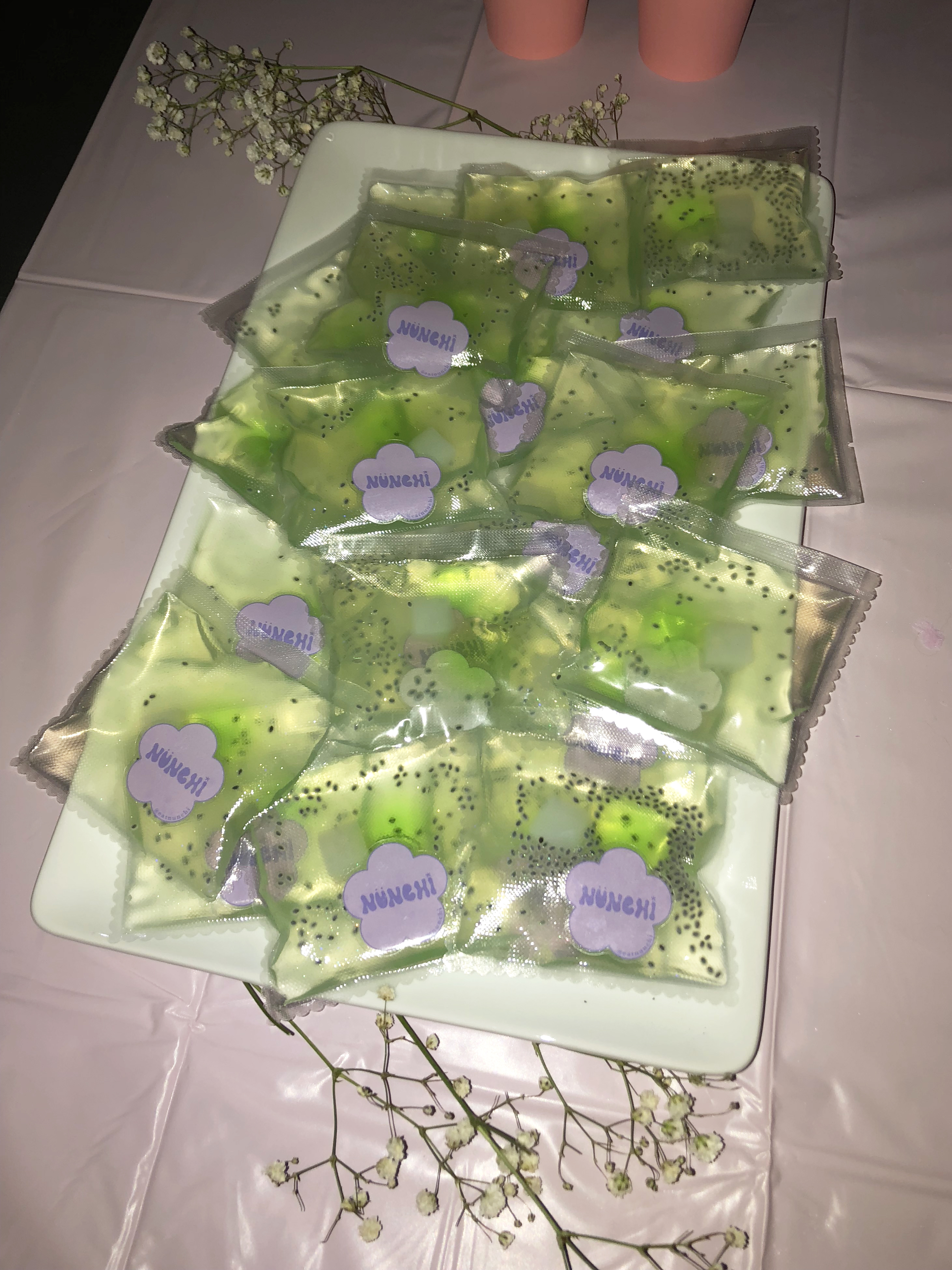 Green jello pouches on a pink table